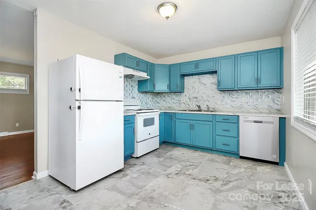 a kitchen with cabinets a refrigerator and a sink