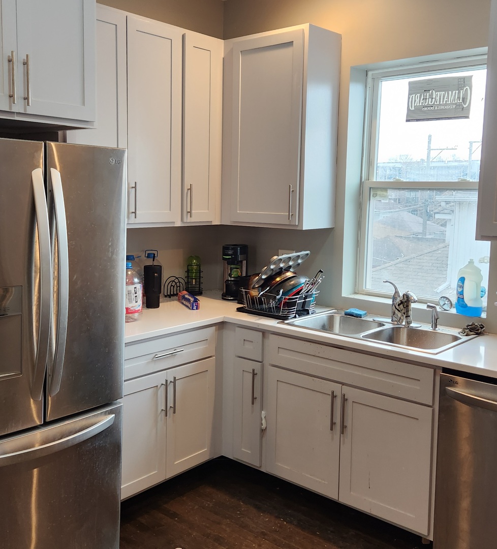 7927 South Justine Street Chicago, IL 60620 - Photo 4 of 9 a kitchen with appliances a sink and cabinets