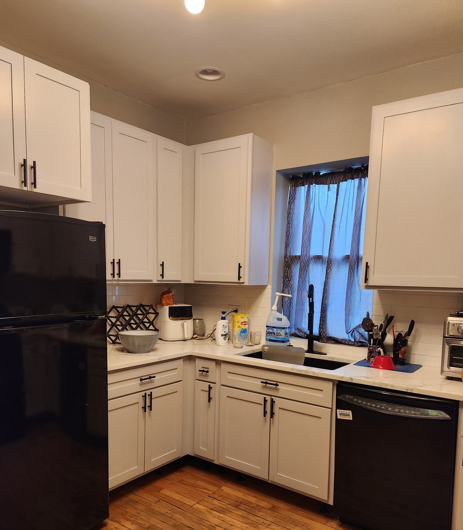 7927 South Justine Street Chicago, IL 60620 - Photo 7 of 9 a kitchen with a sink a refrigerator and cabinets