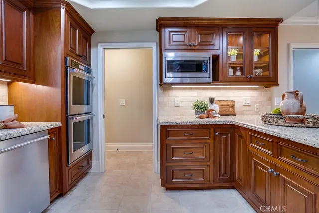 a kitchen with granite countertop stainless steel appliances a sink and cabinets