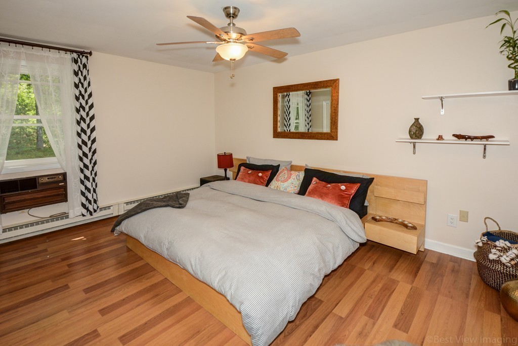854 Great Road Stow, MA 01775 - Photo 6 of 8 a bedroom with a bed and a dresser next to a window