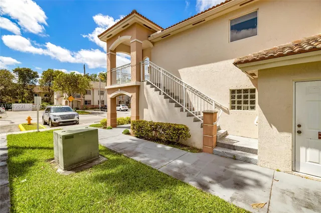 a view of a swimming pool with a lawn chairs under palm trees