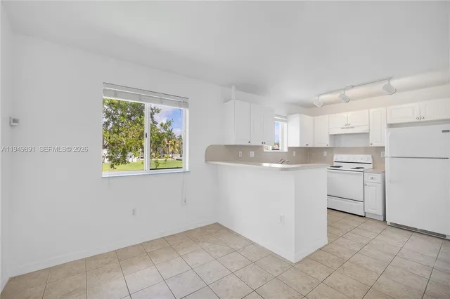 a kitchen with white cabinets and white appliances