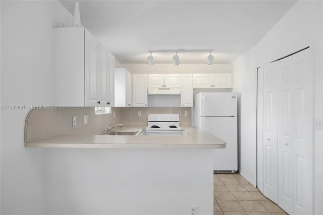 a kitchen with kitchen island a stove a sink and a refrigerator