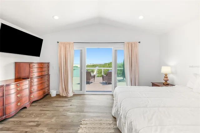 a bedroom with a bed tv and a large window