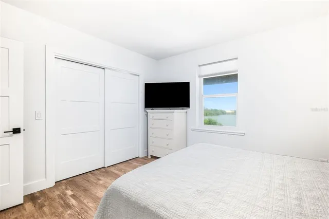 a bedroom with a bed and a flat screen tv