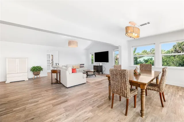 a dining room with stainless steel appliances a table and chairs