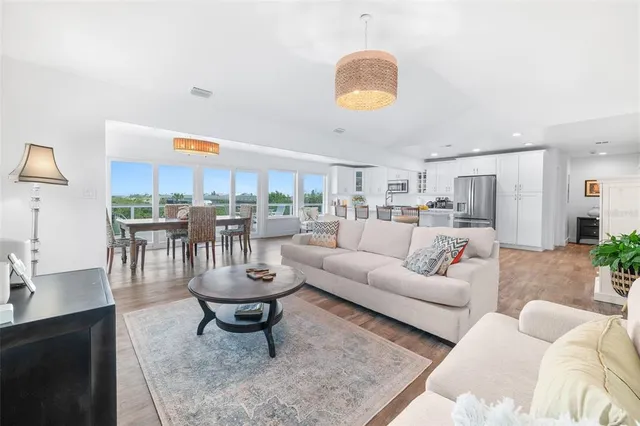 a living room with furniture a table and kitchen view