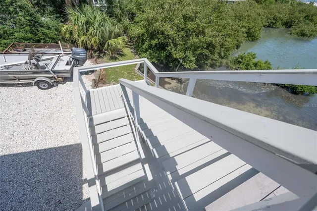 a view of a patio with table and chairs under an umbrella with a large tree