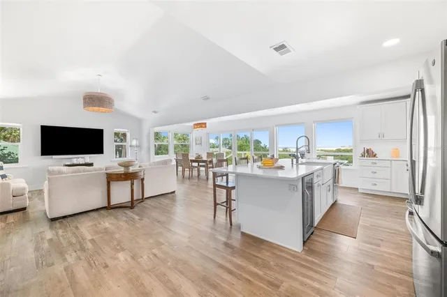 a living room with stainless steel appliances furniture and a flat screen tv