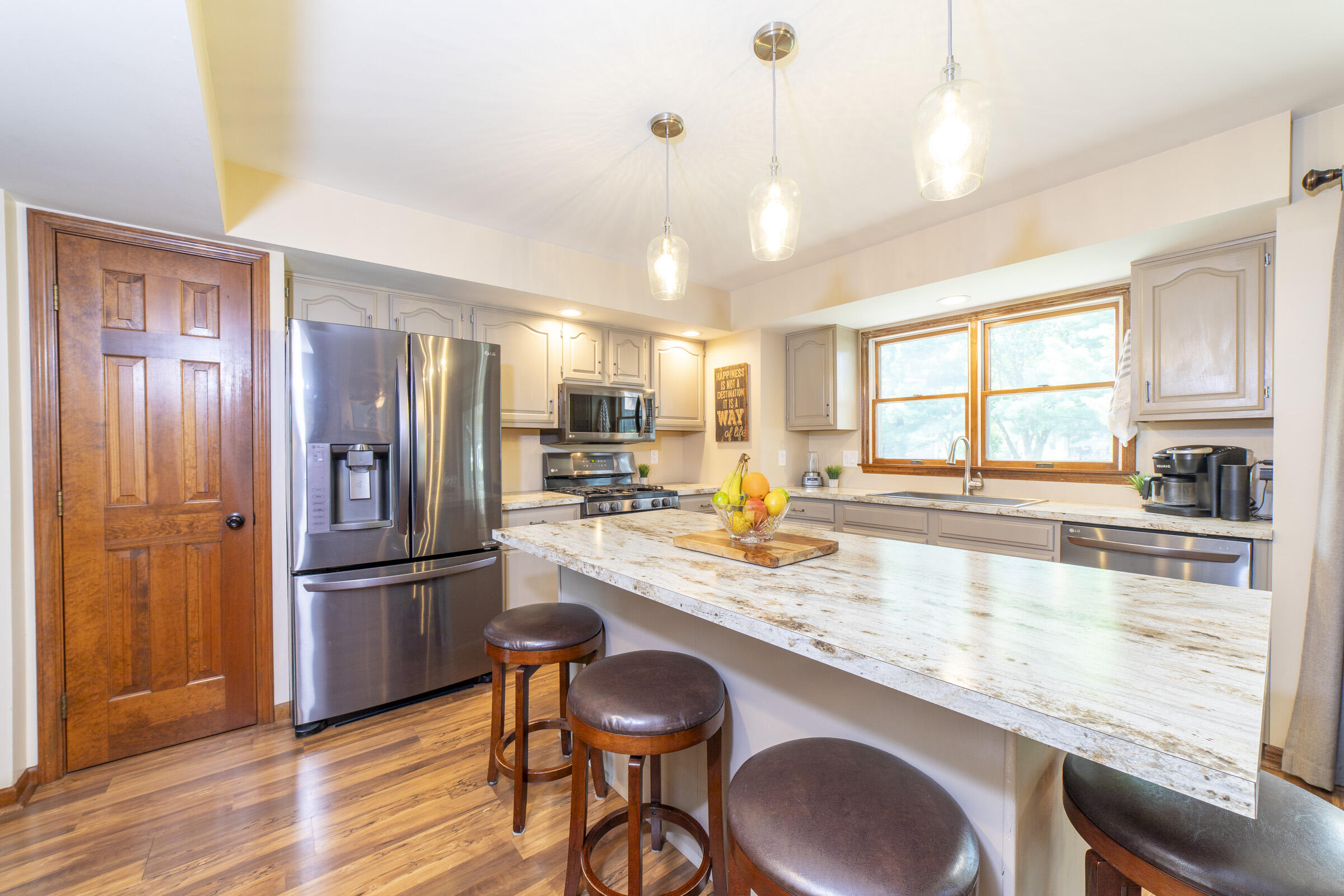 910 Read Drive Chesterton, IN 46304 - Photo 11 of 57 a kitchen with granite countertop a refrigerator a stove a sink dishwasher a dining table and chairs with wooden floor
