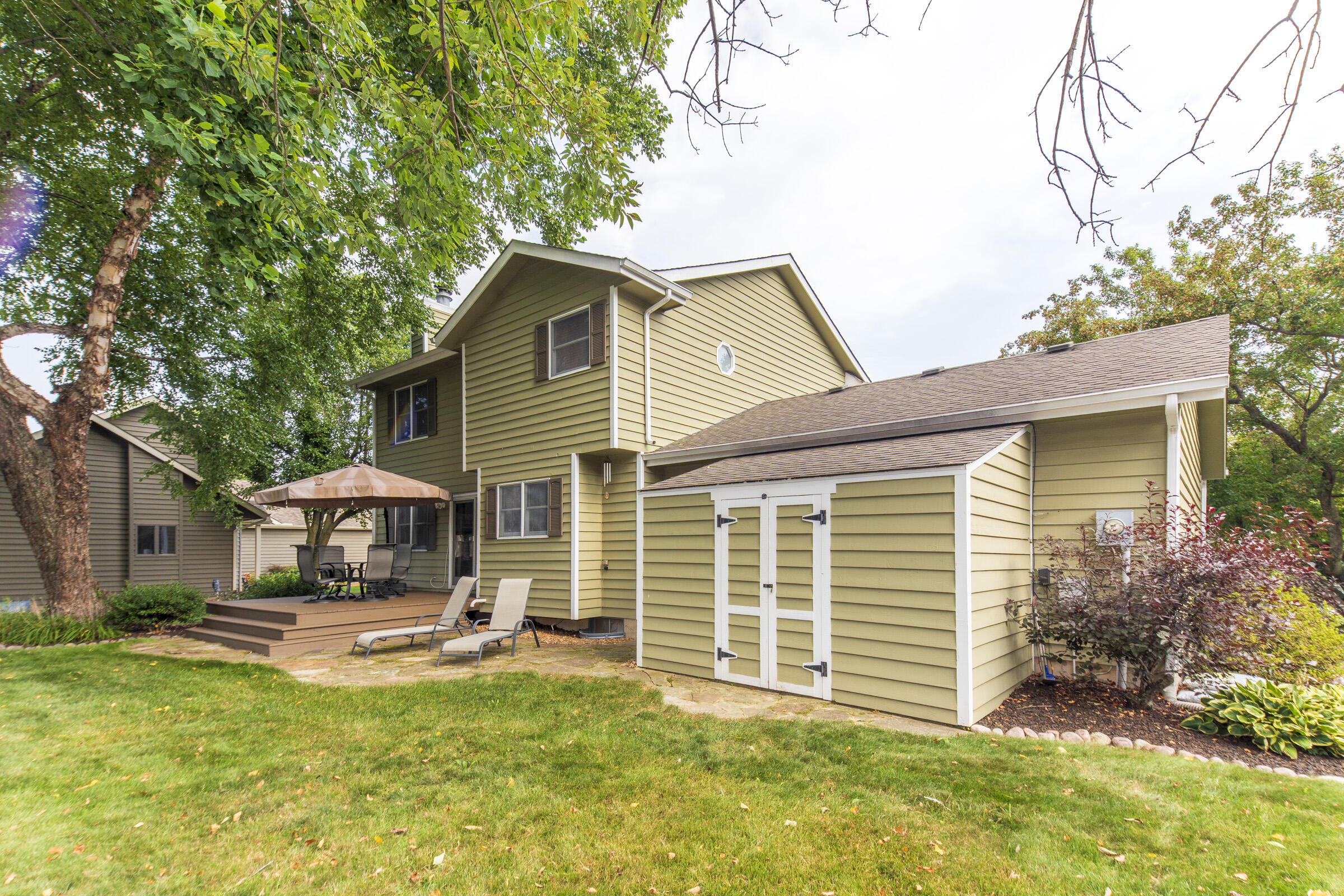 910 Read Drive Chesterton, IN 46304 - Photo 51 of 57 a backyard of a house with table and chairs with plants and large tree