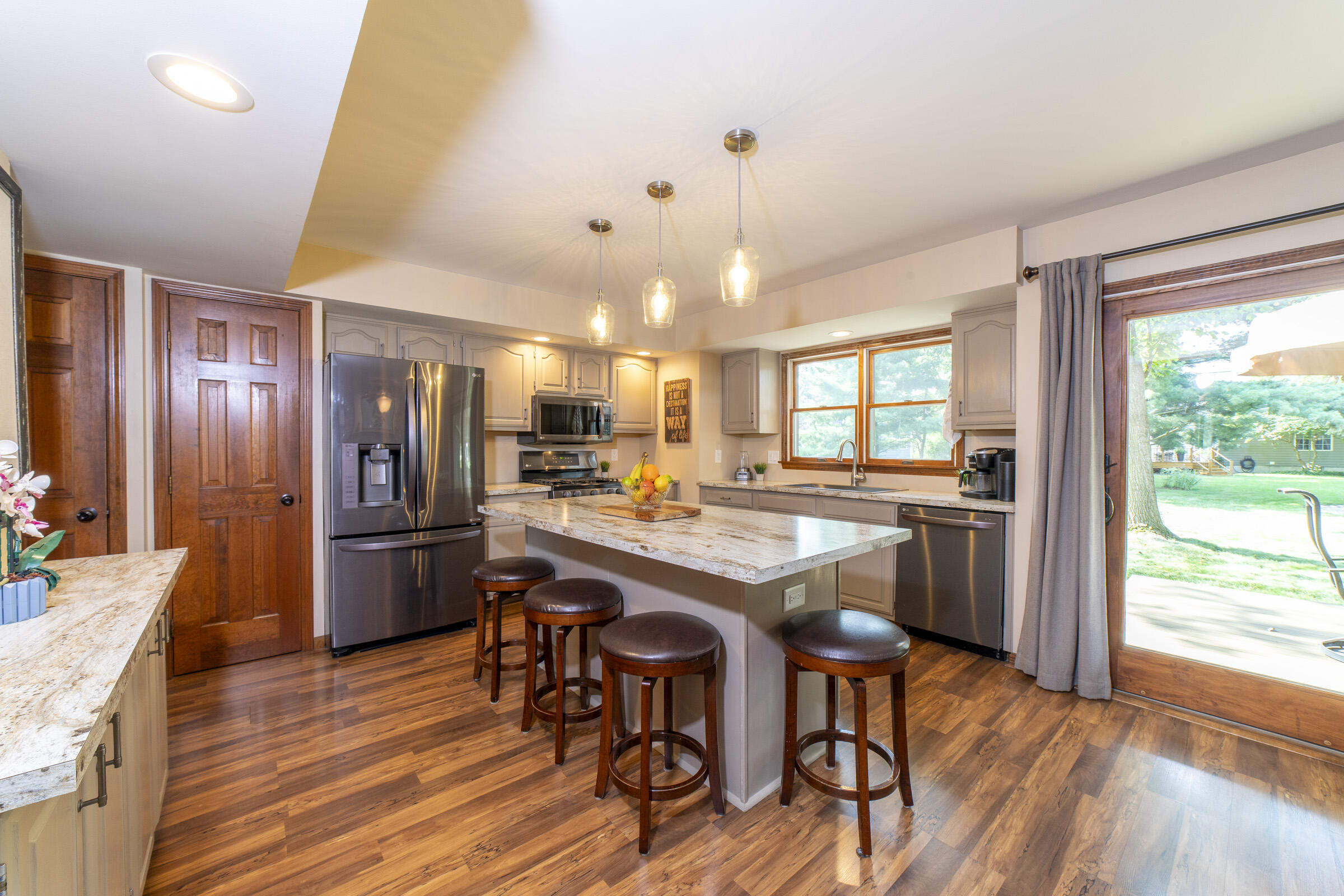 910 Read Drive Chesterton, IN 46304 - Photo 10 of 57 a kitchen with stainless steel appliances granite countertop a refrigerator a sink dishwasher a stove and a dining table with wooden floor
