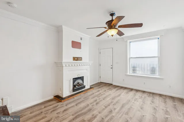 a view of empty room with fireplace and fan