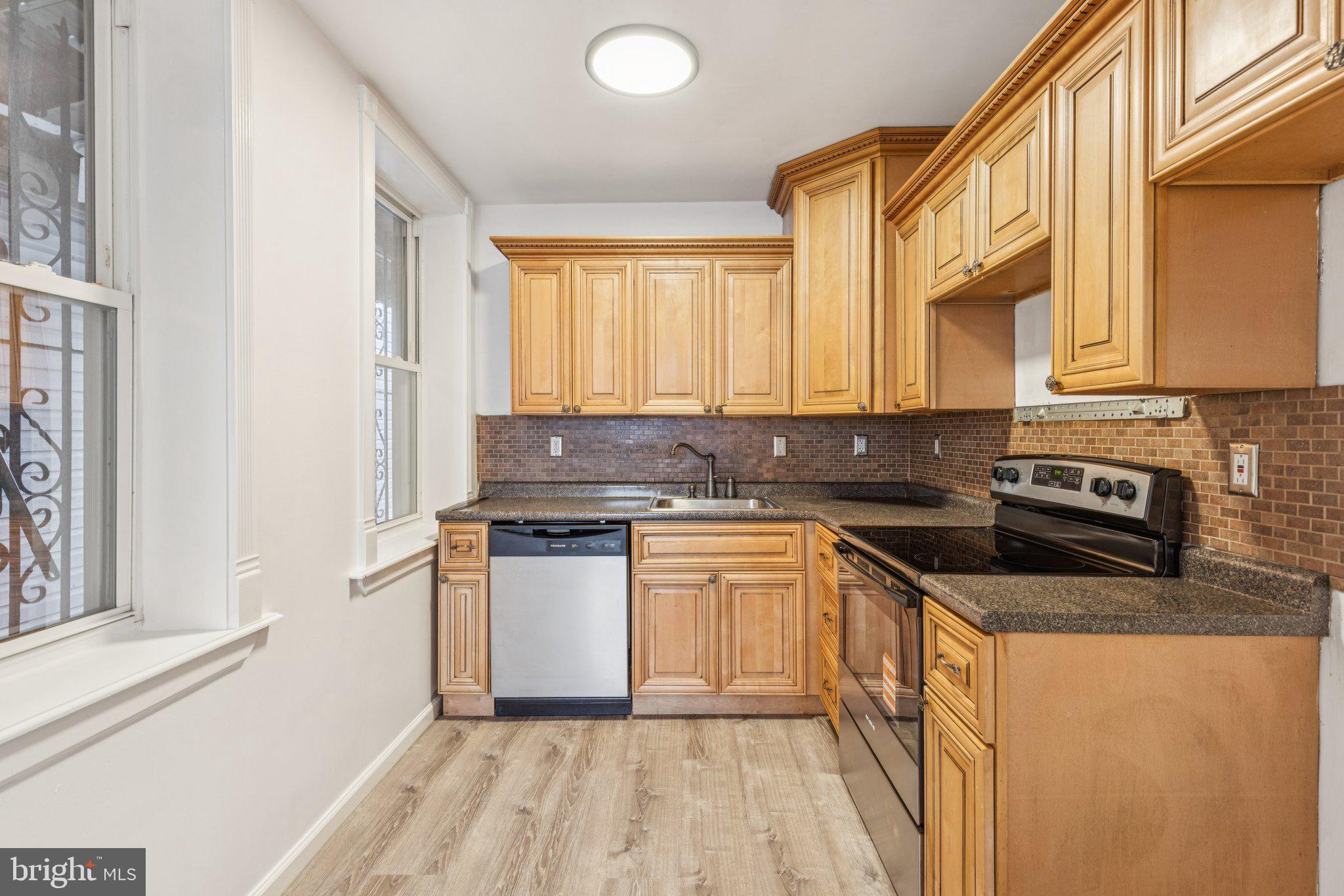 1444 North Perth Street Philadelphia, PA 19122 - Photo 9 of 27 a kitchen with stainless steel appliances granite countertop a stove a sink and a microwave