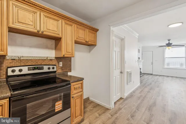 a view of a kitchen with wooden floor and electronic appliances