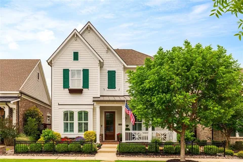 a view of a white house with a small yard and plants