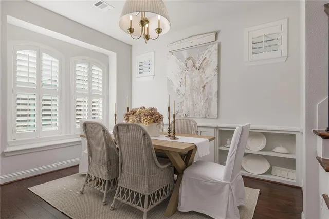 a kitchen with stainless steel appliances granite countertop a table chairs sink and cabinets