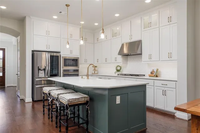 a kitchen with granite countertop a sink stove and cabinets