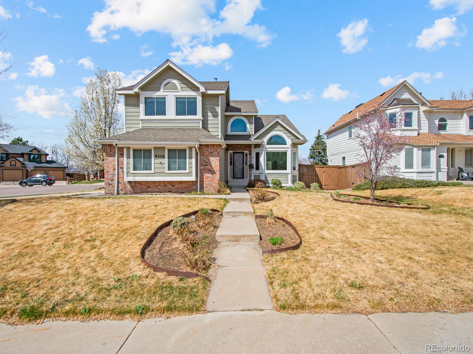 9358 Cornell Circle Highlands Ranch, CO 80130 - Photo 1 of 50 a view of a white house with large windows next to a road