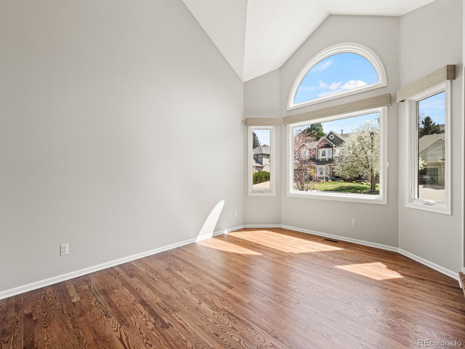 9358 Cornell Circle Highlands Ranch, CO 80130 - Photo 12 of 50 a view of empty room with wooden floor and fan