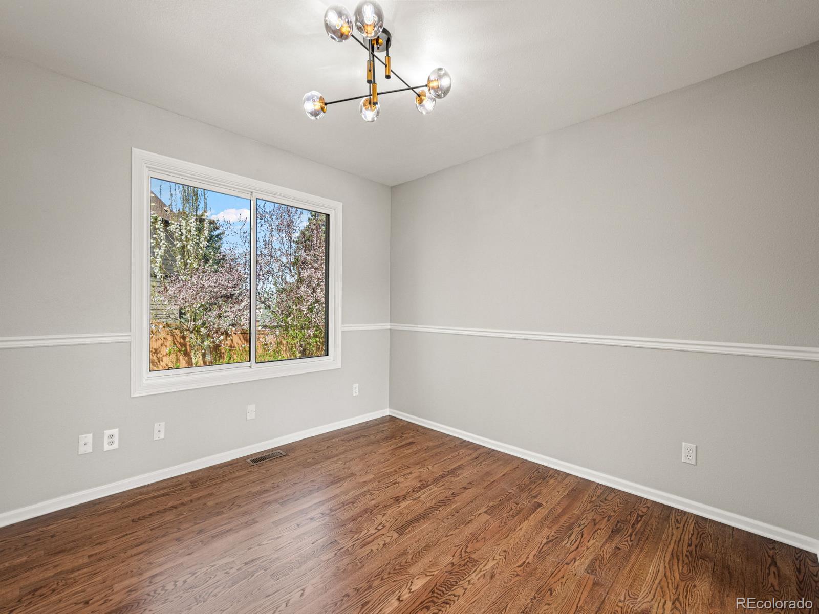 9358 Cornell Circle Highlands Ranch, CO 80130 - Photo 13 of 50 wooden floor in an empty room with a window