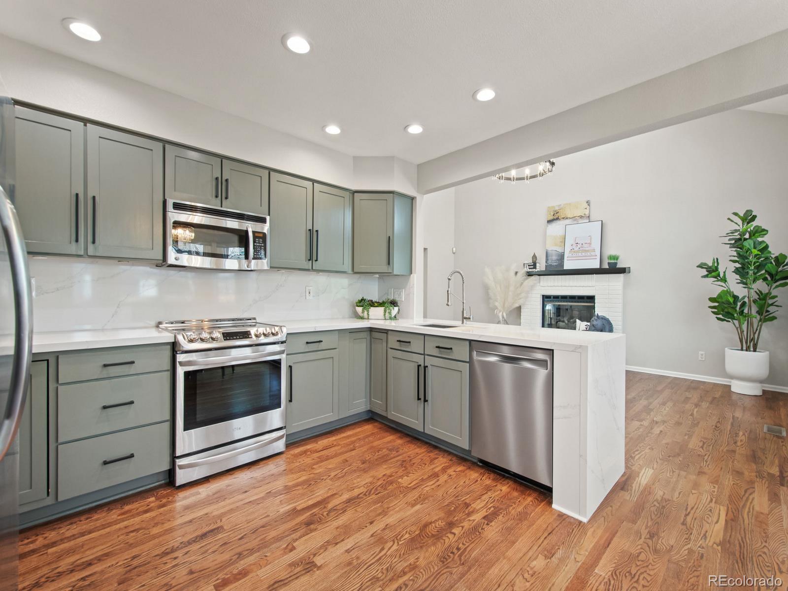 9358 Cornell Circle Highlands Ranch, CO 80130 - Photo 15 of 50 a kitchen with stainless steel appliances granite countertop a stove a sink and a microwave