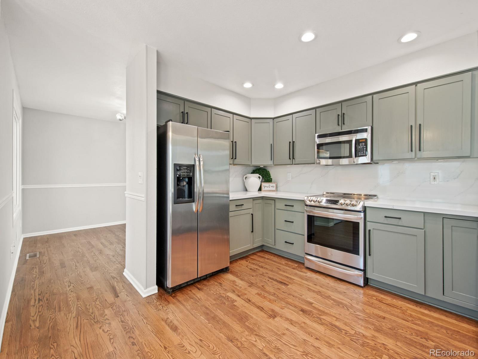 9358 Cornell Circle Highlands Ranch, CO 80130 - Photo 16 of 50 a kitchen with a refrigerator stove and wooden floor