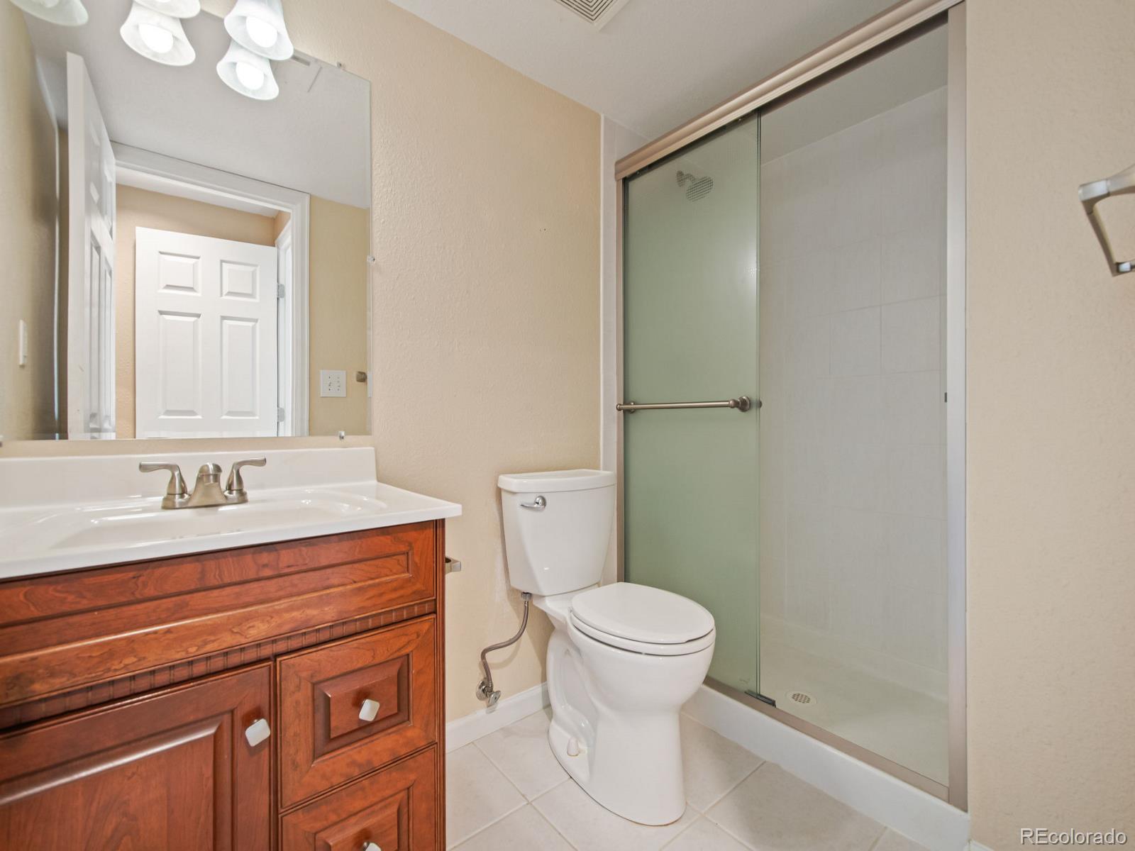 9358 Cornell Circle Highlands Ranch, CO 80130 - Photo 43 of 50 a bathroom with a granite countertop sink toilet and shower
