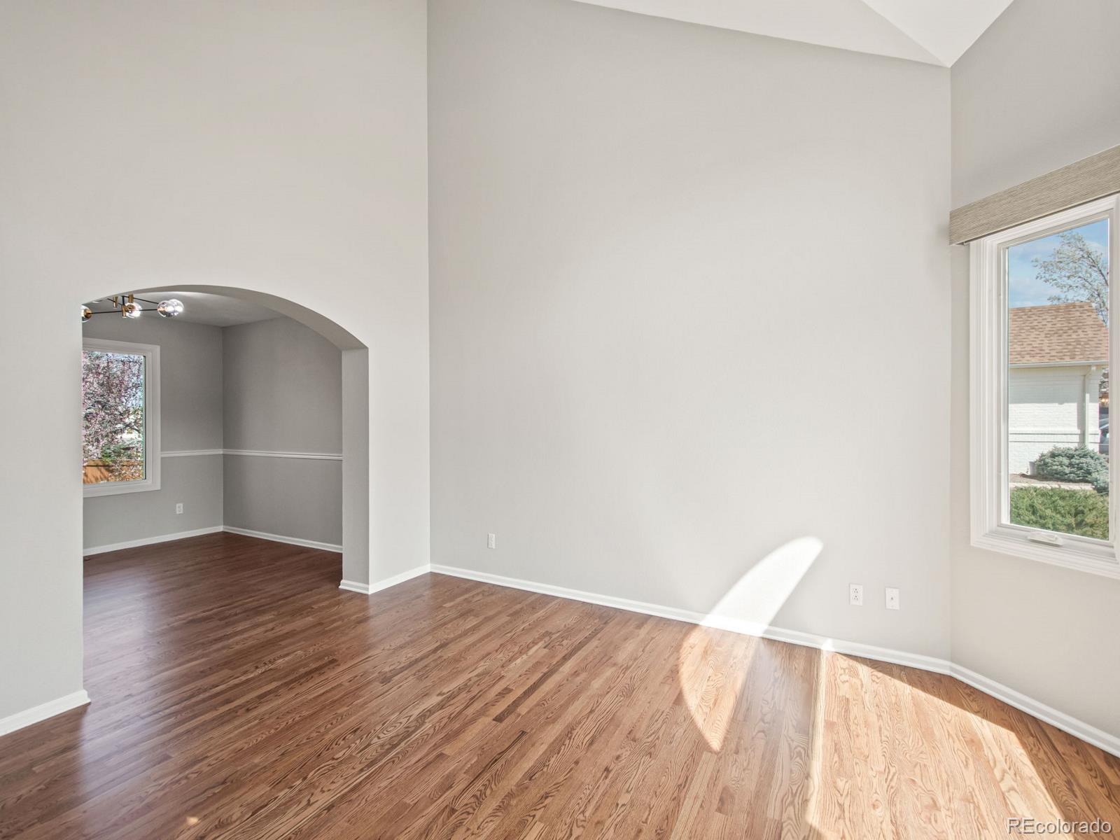 9358 Cornell Circle Highlands Ranch, CO 80130 - Photo 10 of 50 an empty room with wooden floor cabinet and windows