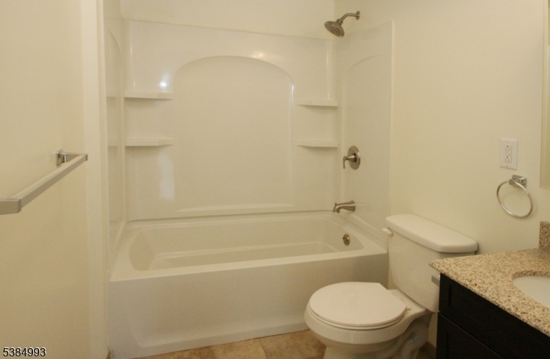 1 Carriage Way, Unit 12 Montclair, NJ 07042 - Photo 14 of 19 a bathroom with a granite countertop toilet a sink and a shower