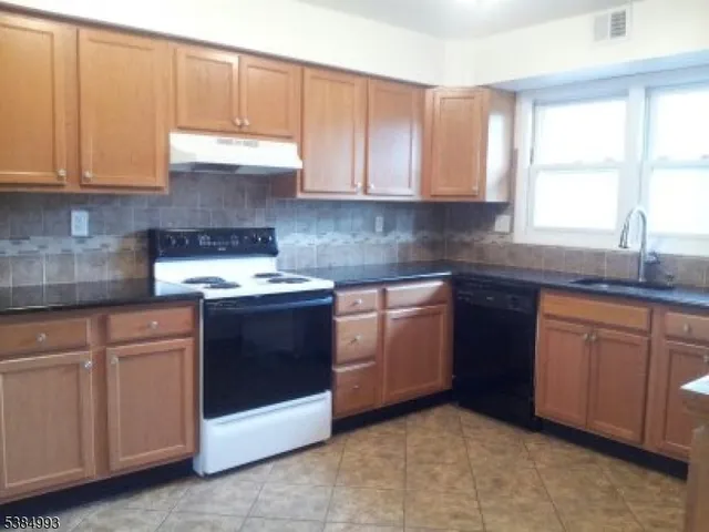 a kitchen with granite countertop white cabinets and white stainless steel appliances