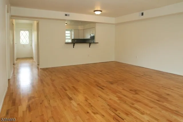 a view of empty room with wooden floor
