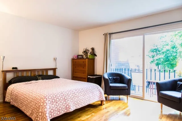 a bedroom with a bed chair and a large window