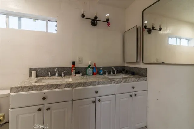 a bathroom with a granite countertop sink mirror and vanity