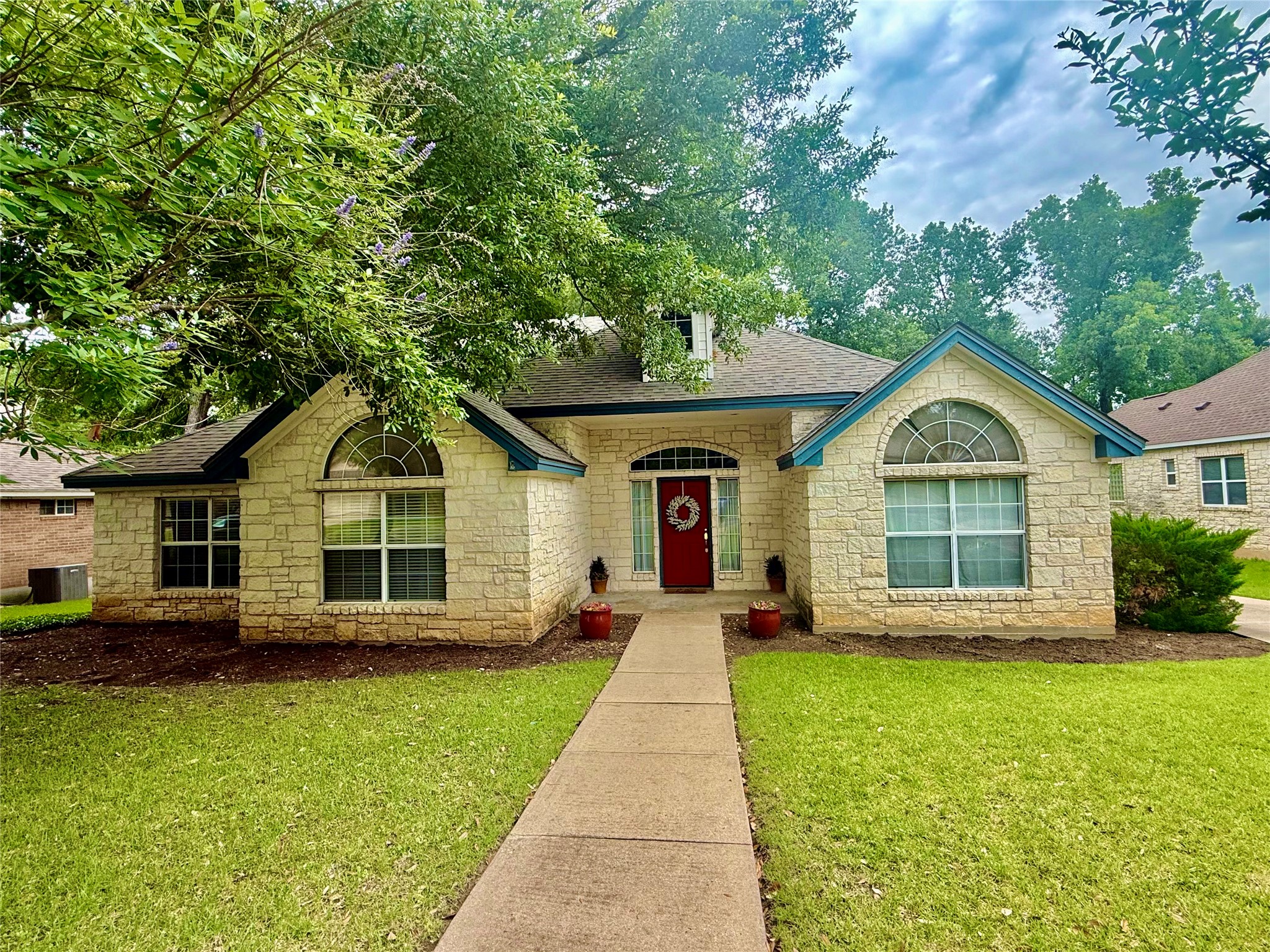 1127 Robin Road Elgin, TX 78621 - Photo 18 of 19 View of front of property with stone siding, a front lawn, and a shingled roof
