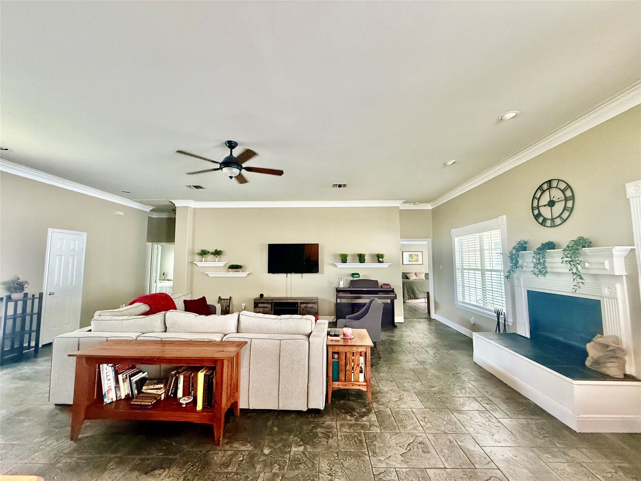 1127 Robin Road Elgin, TX 78621 - Photo 2 of 19 Living room with a fireplace with raised hearth, a ceiling fan, crown molding, baseboards, and recessed lighting