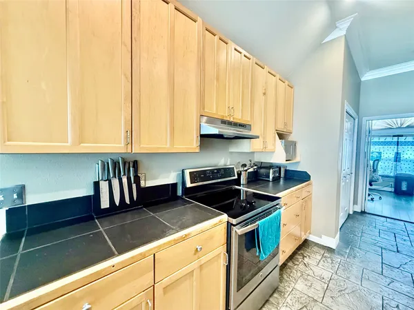 a kitchen with a sink dishwasher a stove a refrigerator and a dining table with wooden floor