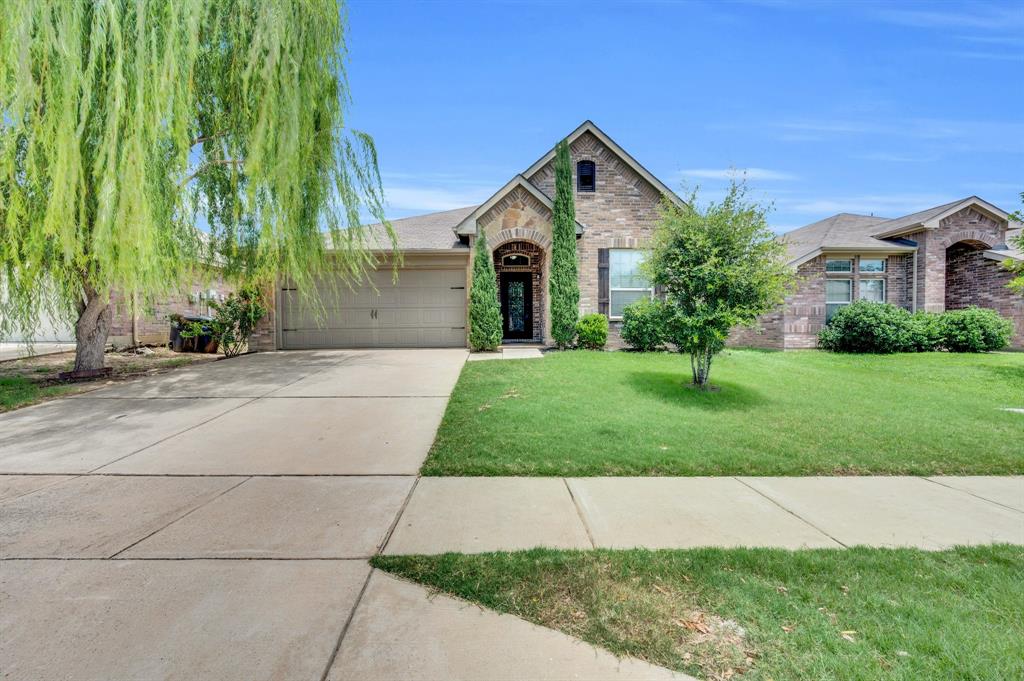 a front view of a house with a yard and trees