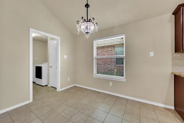 an empty room with chandelier and windows