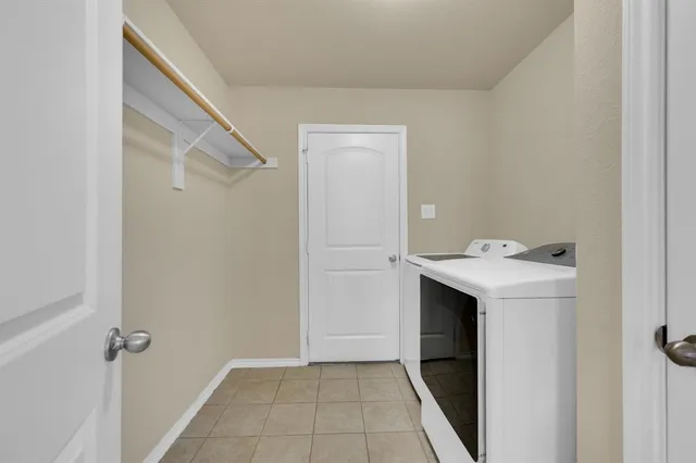 a utility room with cabinets washer and dryer