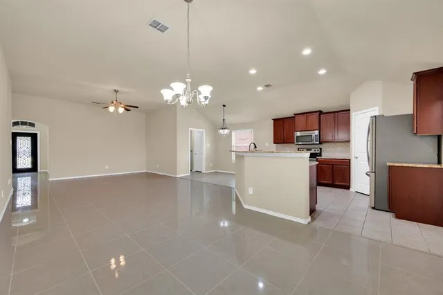 a view of a kitchen with kitchen island a sink stainless steel appliances and cabinets