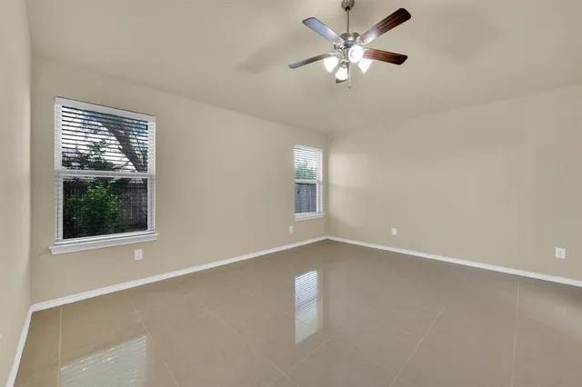 an empty room with a window and a fan