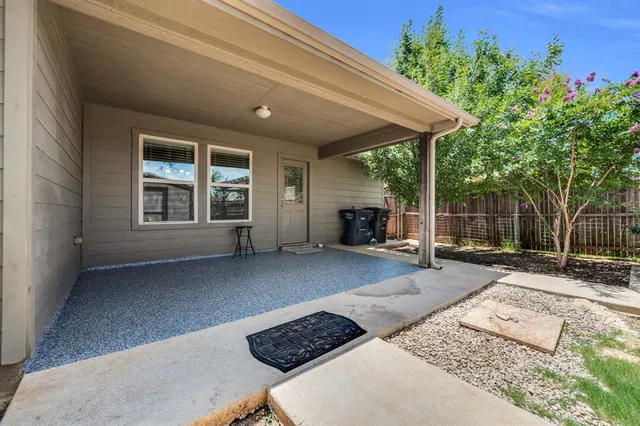 front view of a house with a large window and potted plants