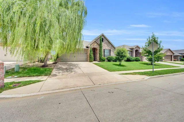 a front view of a house with a yard and trees