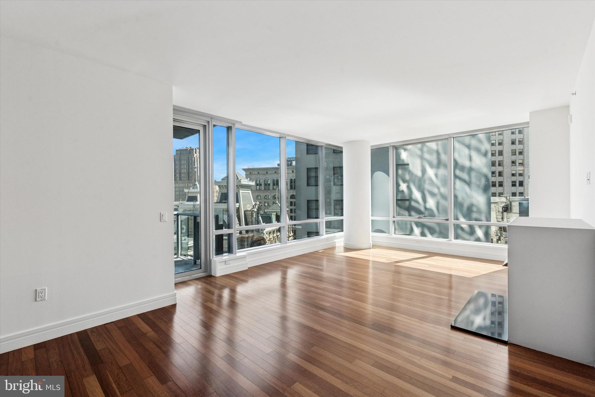 1414 South Penn Square, Unit 18B Philadelphia, PA 19102 - Photo 3 of 52 a view of an empty room with wooden floor and a window