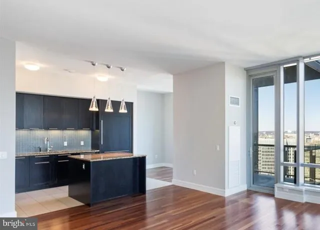 a view of kitchen with granite countertop stainless steel appliances counter space and wooden floor