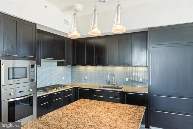 a kitchen with stainless steel appliances granite countertop a sink stove and cabinets