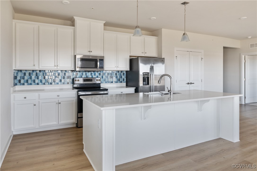 3700 Maze Runner Drive, Unit 405 Midlothian, VA 23112 - Photo 12 of 28 a kitchen with stainless steel appliances granite countertop a sink a stove a refrigerator and island with wooden floor