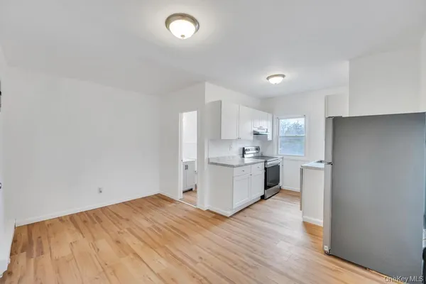 a kitchen with a refrigerator and white cabinets